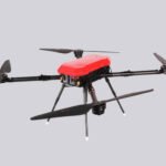 A red and black quadcopter drone with four propellers is shown against a plain gray background.