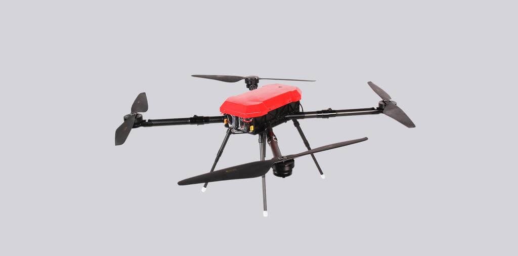 A red and black quadcopter drone with four propellers is shown against a plain gray background.