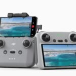 Two drone controllers with attached screens displaying aerial views of a beach.