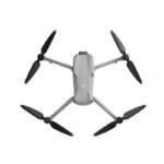 A gray quadcopter drone with four propellers is viewed from above on a white background.