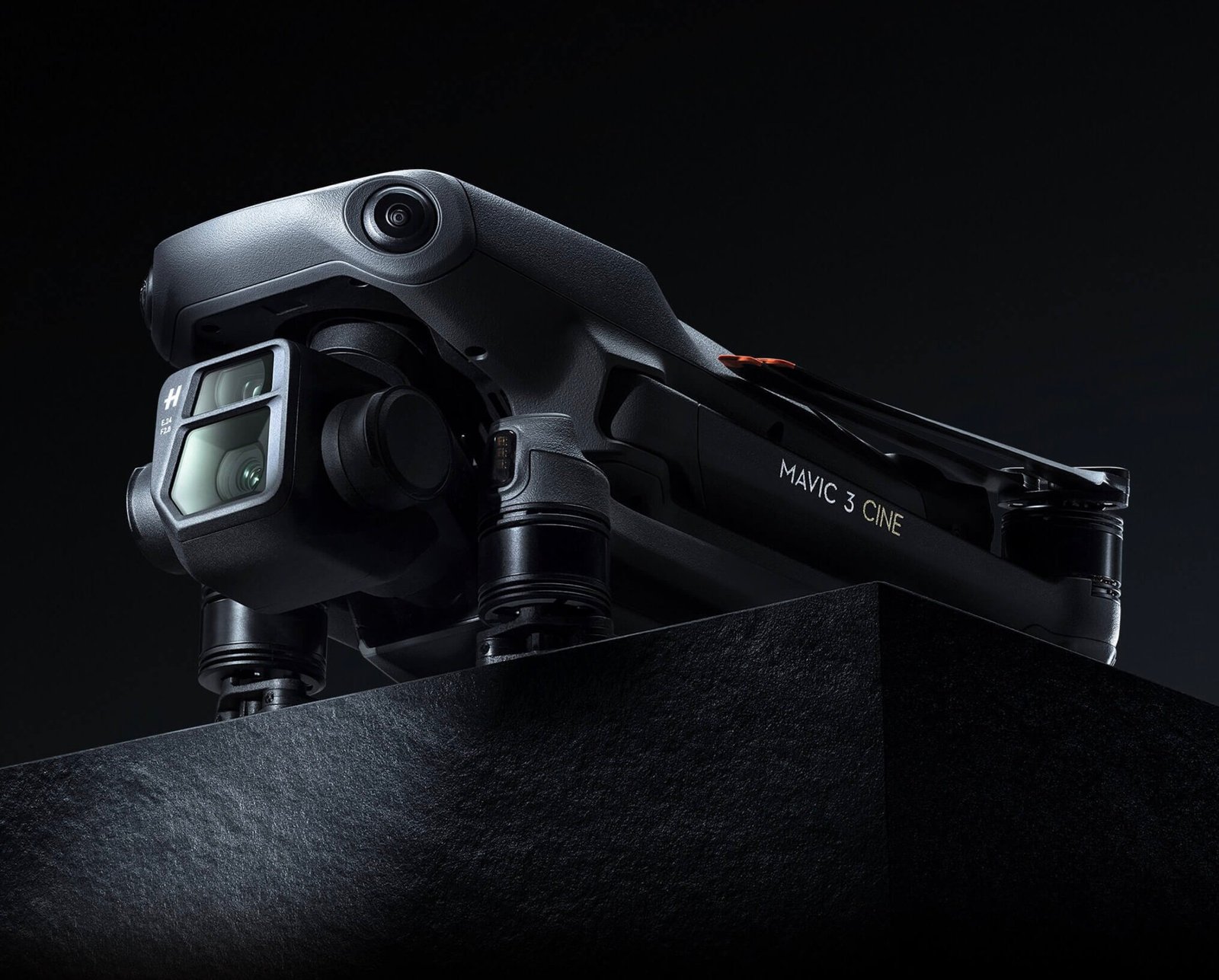 A DJI Mavic 3 Cine drone is placed on a dark platform, featuring a prominent camera lens and sleek design.