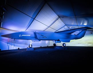 A modern unmanned aerial vehicle displayed in a well-lit indoor tent with a blue and white color scheme.