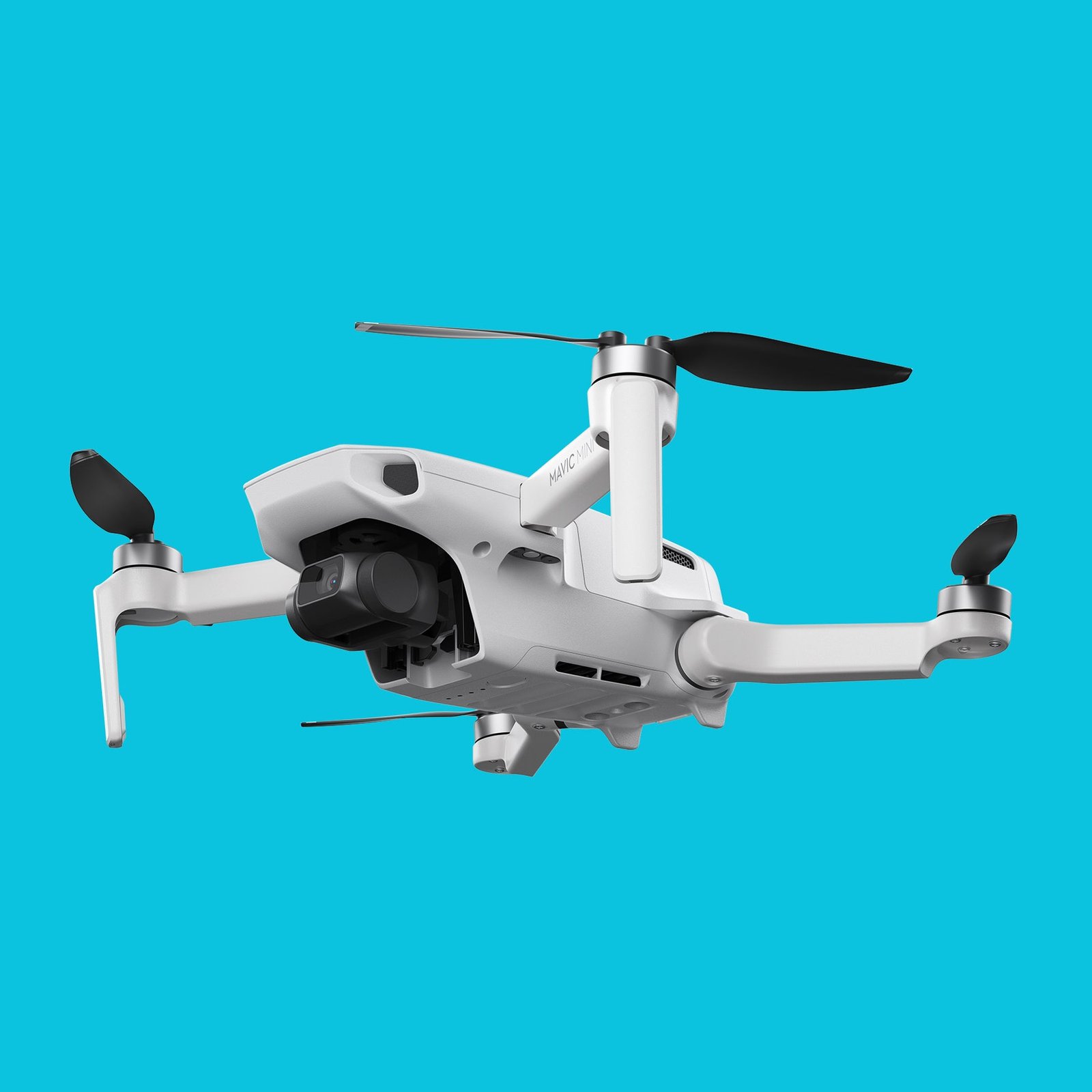 A small, white quadcopter drone with black propellers and a mounted camera, hovering against a solid turquoise background.