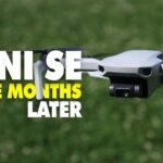 DJI Mini SE drone flying over grass with text overlay: "MINI SE Three Months Later.