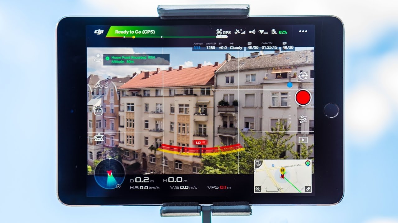 Tablet displaying a drone control screen with camera feed of a residential building and various flight data like speed, altitude, and GPS status.