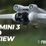 Close-up of a DJI Mini 3 Pro drone in flight, featuring its camera and propellers. Text overlay reads, "DJI Mini 3 Pro Review" with the ProfileTree logo.