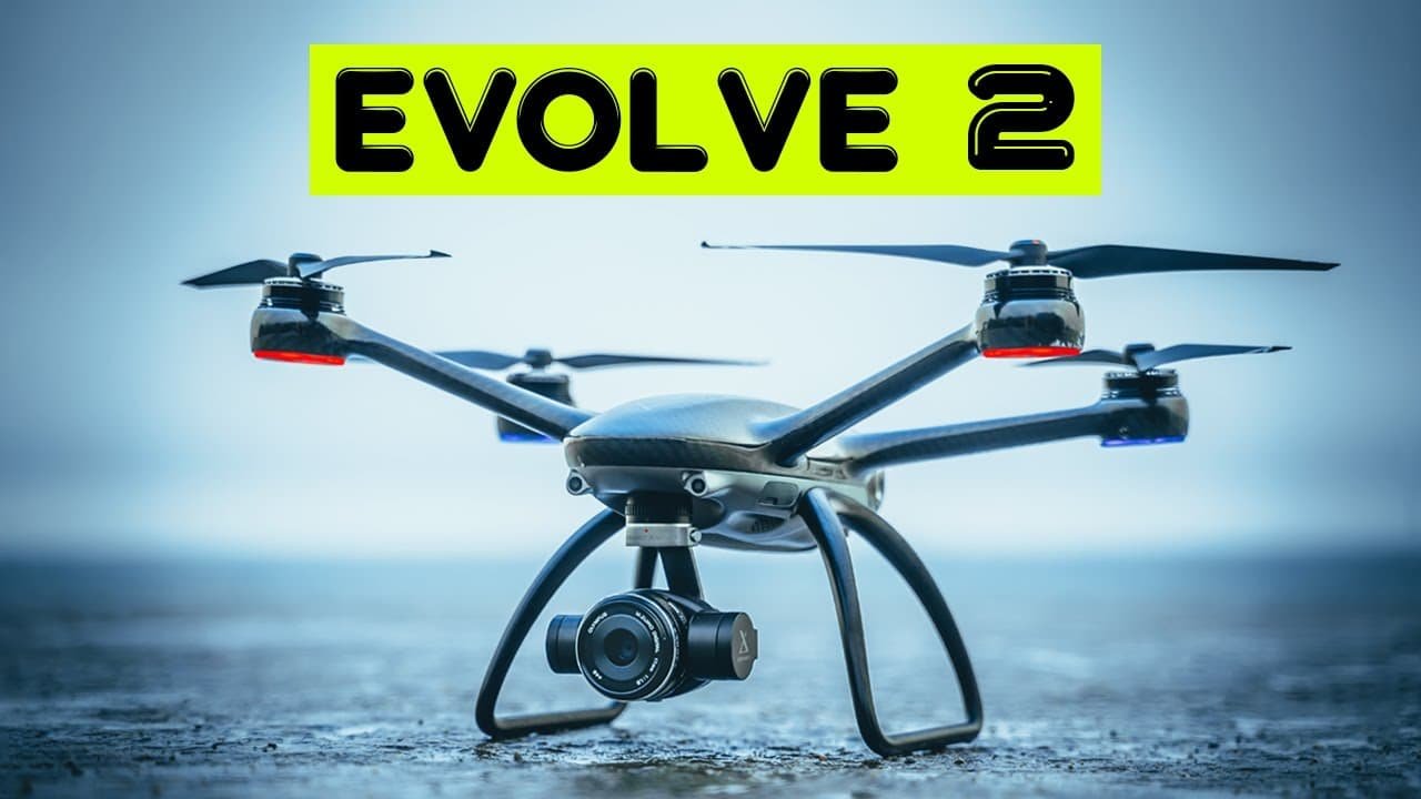 A black quadcopter drone with a camera, labeled "EVOLVE 2," hovers against a light blue background.